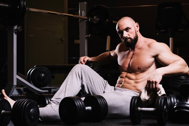 Man in sweatpants amidst barbells