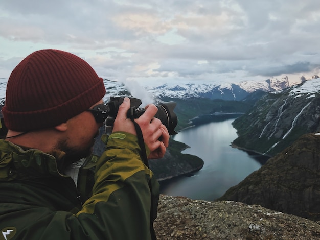 Free Photo man takes a picture of gorgeous scandinavian landscape