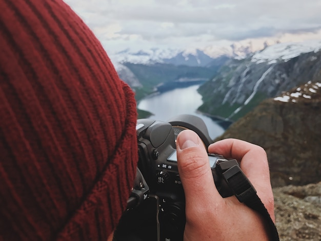 Free photo man takes a picture of gorgeous scandinavian landscape