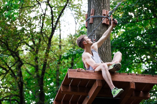 Free photo man takes selfie sitting on the tree