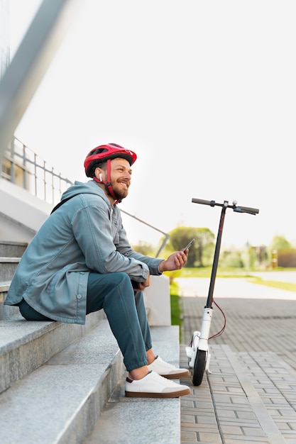 Man taking a break after riding his scooter