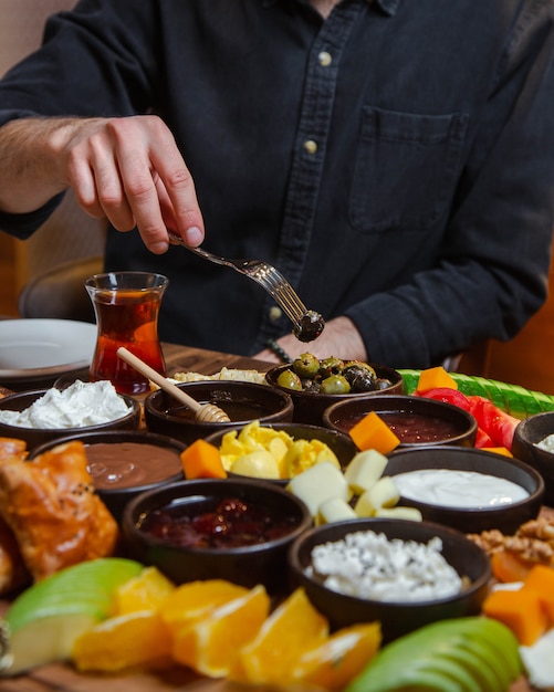 Man taking food from fully donated breakfast table with mixed foods.