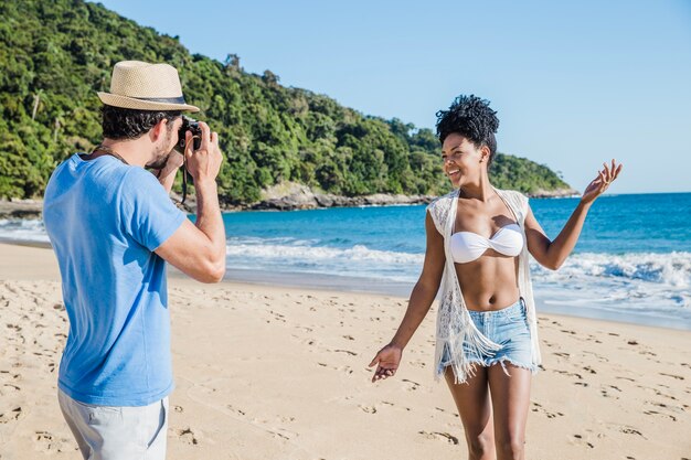 Man taking foto of girlfriend at the beach