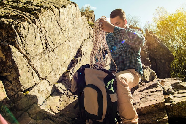 Free photo man taking out rope from backpack