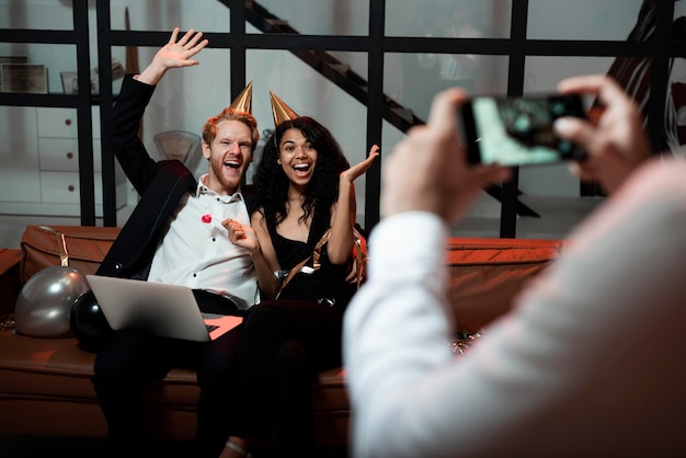 Free photo man taking a photo of his friends at new year's eve party