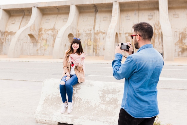 Man taking photo of smiling woman gesturing