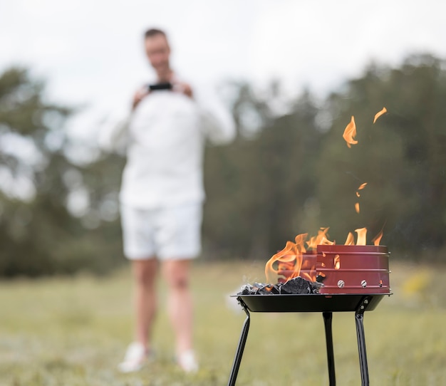 Free Photo man taking picture of barbecue outdoors