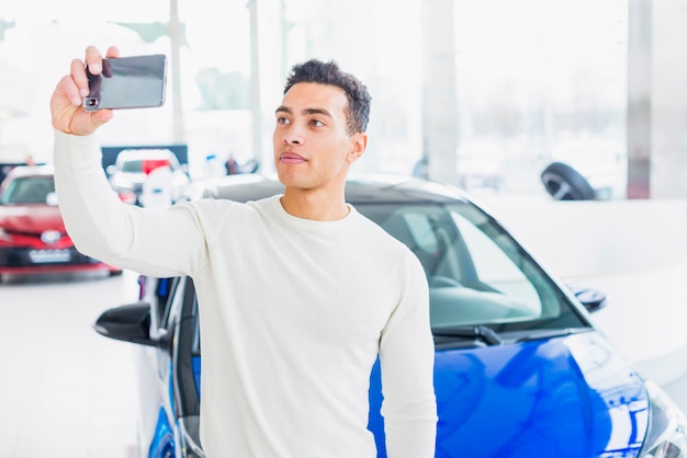 Man taking selfie in car dealership