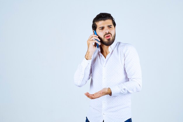 Man talking to his blue new model smartphone