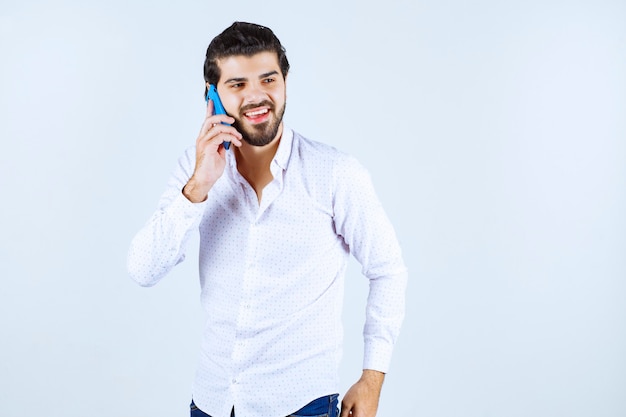 Man talking to his blue new model smartphone