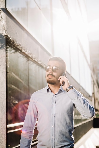 Free photo man talking phone in backlit