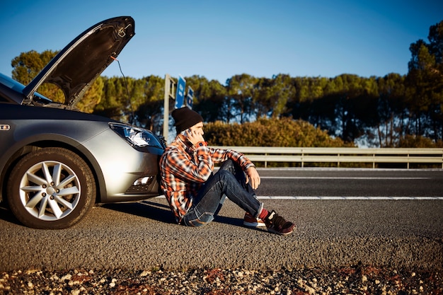 Man talking on the phone next to car