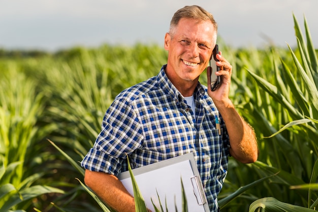 Free photo man talking on the phone in a field