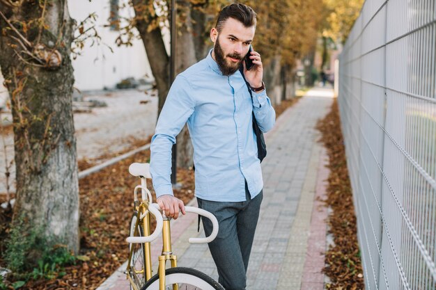 Man talking on phone near fence