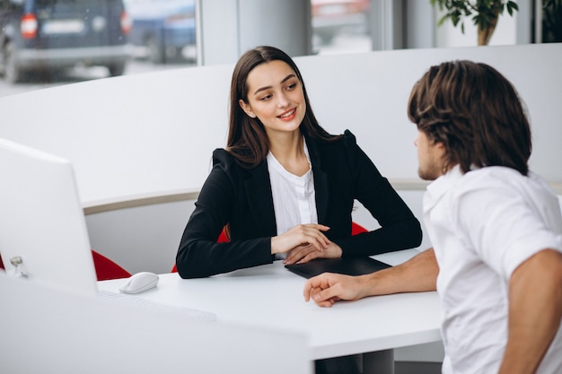 Man talking with female sales person in a car show room