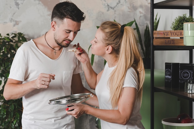 Free photo man tasting the prepared mushroom by blonde young woman