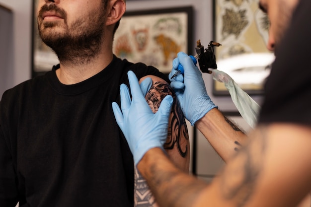 Man tattooing with gloves side view