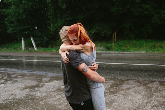 Free Photo man throws up his girlfriend in the rain