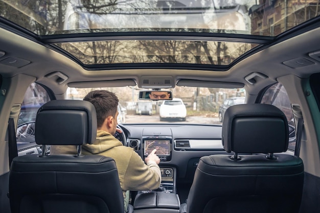 Free photo man touching screen of a gps navigation system in his car