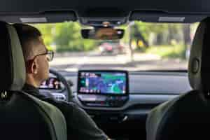 Free photo man touching screen of a gps navigation system in his car