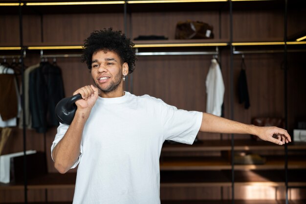 Man training with kettlebell in closet medium shot