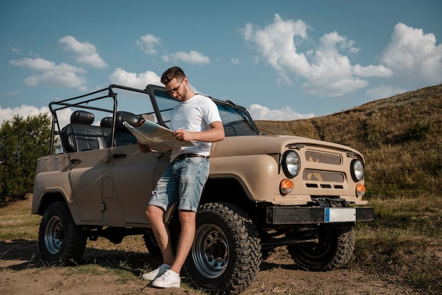 Man traveling by car and looking at map