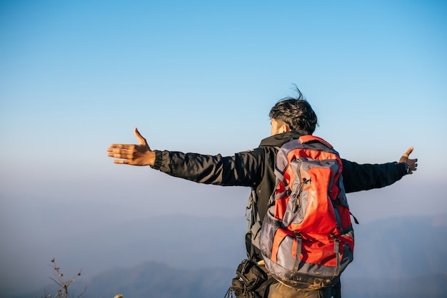 Man traveling with backpack hiking in mountains 