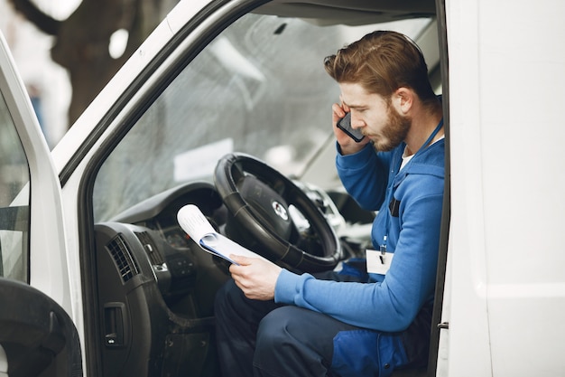 Free photo man in the truck. guy in a delivery uniform. man with clipboard.