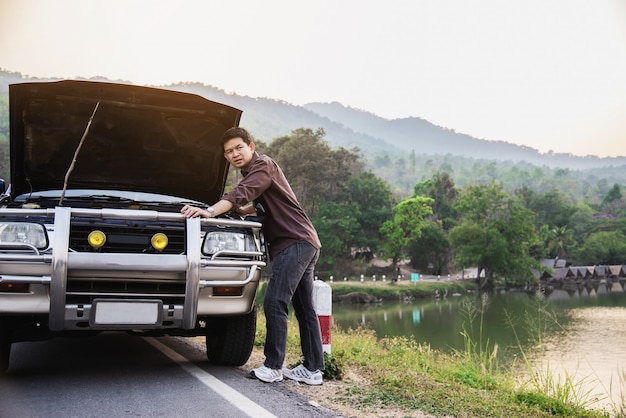 Free Photo man try to fix a car engine problem on a local road chiang mai thailand 