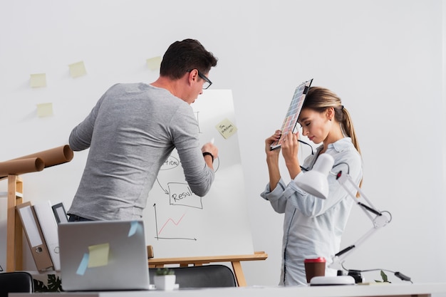 Free photo man trying to explain diagram to female colleague