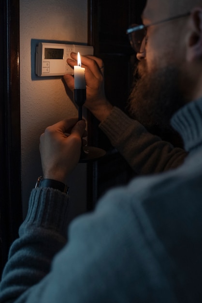 Free Photo man turning off thermostat during energy crisis