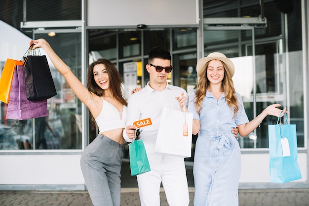 Free photo man and two women with paper bags