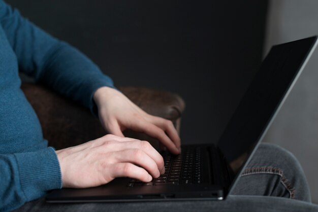 Man typing on the keyboard of his laptop