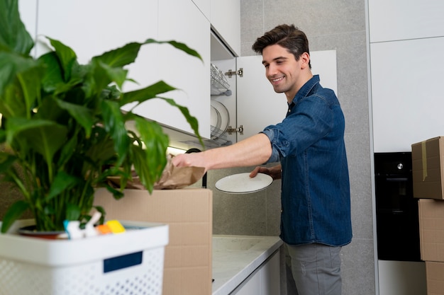 Man unpacking belongings after moving in a new house