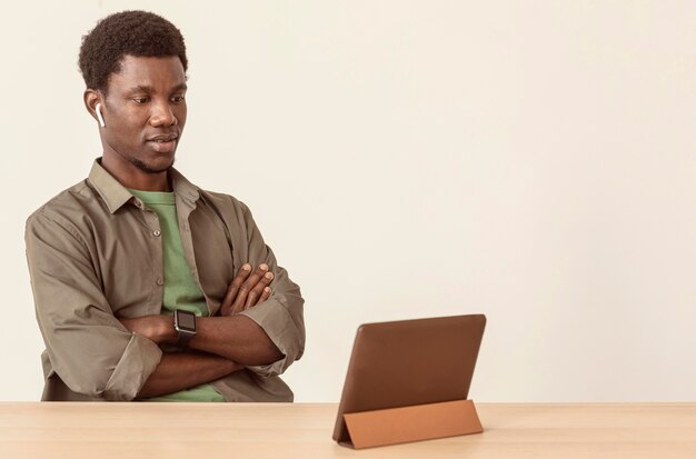 Man using air pods and looking at digital tablet