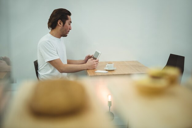 Man using digital tablet in coffee shop