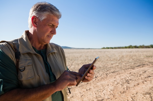 Man using digital tablet on landscape