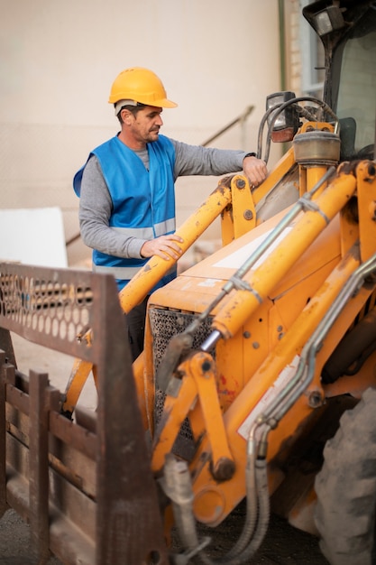 Free photo man using an excavator for digging on day light