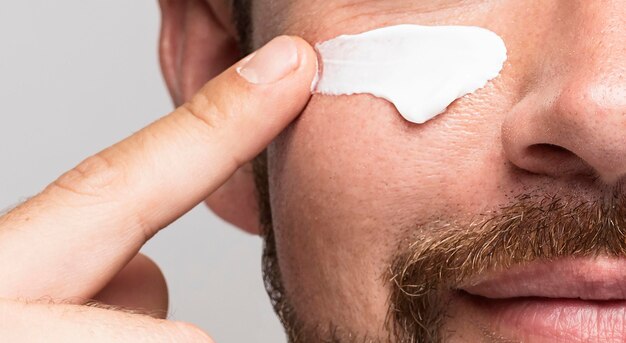 Man using face cream close-up