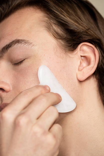 Man using gua sha tool close up