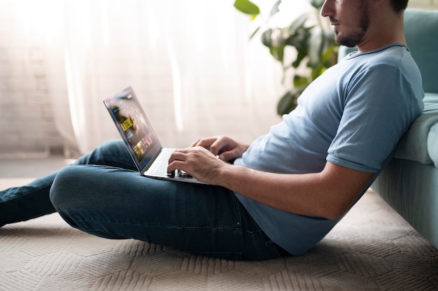 Man using his laptop with digital assistant at home