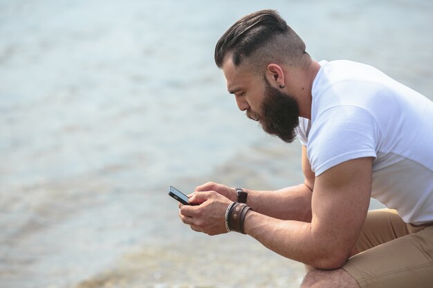 Man using his mobile by the lake