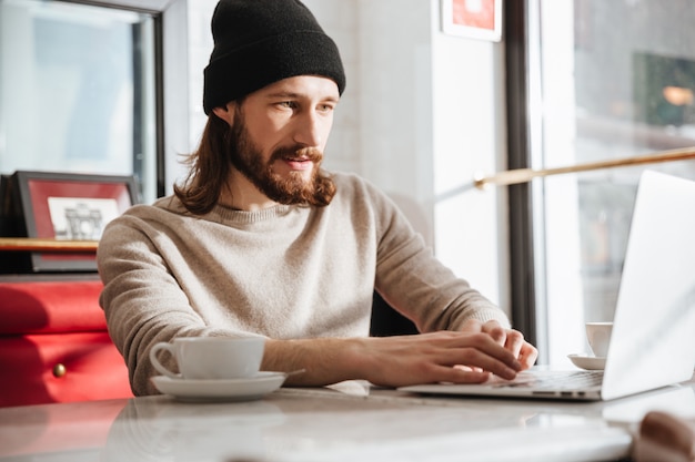 Man using laptop in cafe