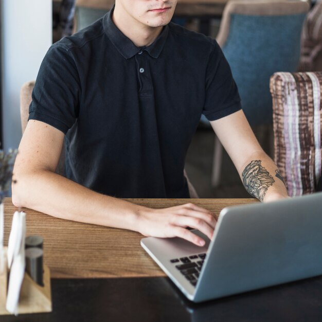 Man using laptop in cafe