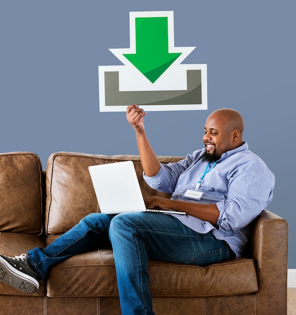 Free Photo man using a laptop and holding a download icon