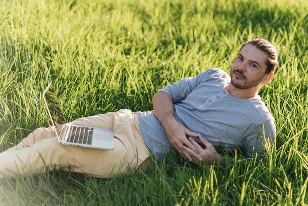 Free Photo man using laptop in park