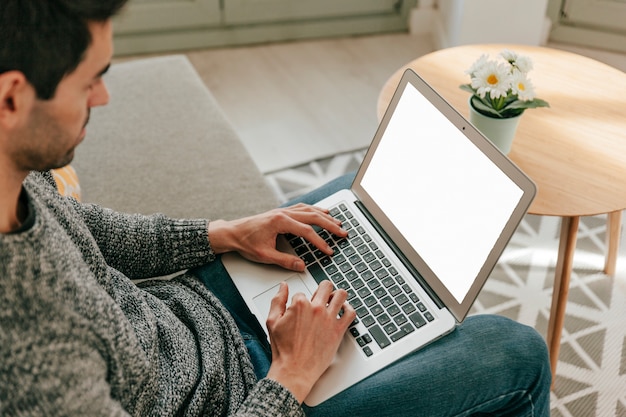 Free photo man using laptop on sofa