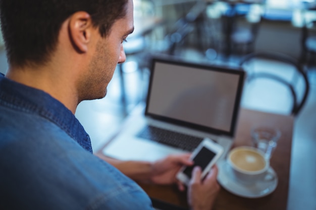 Man using mobile phone in cafÃ©