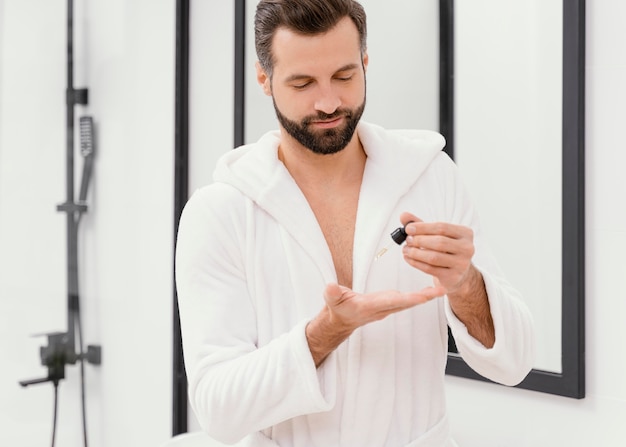 Free photo man using natural oils for his face