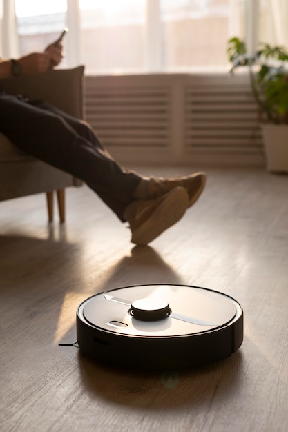 Man using a robot vacuum in the living room